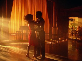 Movie still from “One from the Heart” (1981), directed by Francis Ford Coppola – A man and a woman dancing in front of a stage; Wide shot, Low angle