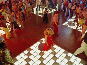 Movie still from “One from the Heart” (1981), directed by Francis Ford Coppola – A group of people dancing in a room with lights; Wide shot, Overhead angle