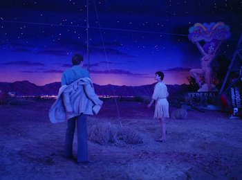 Movie still from “One from the Heart” (1981), directed by Francis Ford Coppola – A man and a woman standing next to each other in the desert at night; Wide shot, Low angle