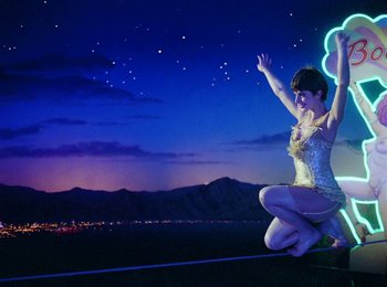 Movie still from “One from the Heart” (1981), directed by Francis Ford Coppola – A woman in a white dress is standing on the ground; Wide shot, Low angle