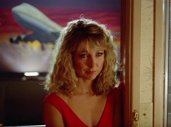 Movie still from “One from the Heart” (1981), directed by Francis Ford Coppola – A woman in a red dress is standing in front of a door; Close Up shot, Low angle