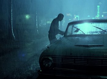Movie still from “One from the Heart” (1981), directed by Francis Ford Coppola – A man washing a car in the pouring rain; Wide shot, Low angle