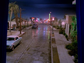 Movie still from “One from the Heart” (1981), directed by Francis Ford Coppola – An empty street at night with neon signs lit up; Extreme Wide shot, High angle