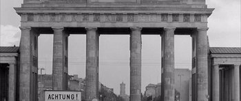 Movie still from “One, Two, Three” (1961), directed by Billy Wilder – A black and white photo of a building with pillars; Wide shot, Low angle