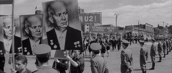 Movie still from “One, Two, Three” (1961), directed by Billy Wilder – A black and white photo of people marching in a parade; Medium shot, Low angle