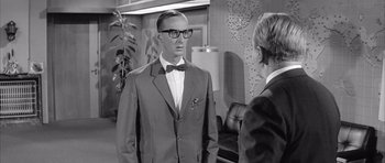 Movie still from “One, Two, Three” (1961), directed by Billy Wilder – A man in a suit and bow tie talking to another man in a suit and bow tie; Medium shot, Over the shoulder angle