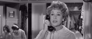 Movie still from “One, Two, Three” (1961), directed by Billy Wilder – An older woman talking on a phone in a black and white photo; Close Up shot, High angle
