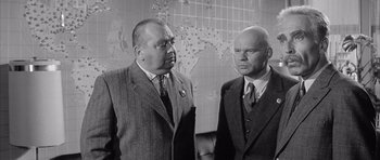 Movie still from “One, Two, Three” (1961), directed by Billy Wilder – A black and white photo of two men standing next to each other; Medium shot, Low angle