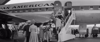 Movie still from “One, Two, Three” (1961), directed by Billy Wilder – A black and white photo of people boarding an airplane; Wide shot, High angle