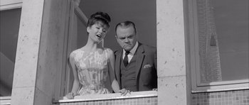 Movie still from “One, Two, Three” (1961), directed by Billy Wilder – An old photo of a man and a woman standing next to each other; Medium shot, Low angle
