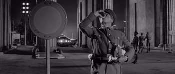 Movie still from “One, Two, Three” (1961), directed by Billy Wilder – A man in a uniform drinking from a bottle; Medium shot, Low angle