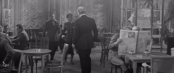 Movie still from “One, Two, Three” (1961), directed by Billy Wilder – An older man in a suit walking through a room; Medium shot, Over the shoulder angle
