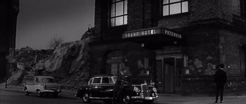 Movie still from “One, Two, Three” (1961), directed by Billy Wilder – An old car parked in front of a building at night; Wide shot, Low angle