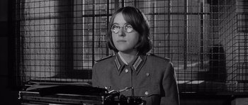 Movie still from “One, Two, Three” (1961), directed by Billy Wilder – A woman wearing glasses and a military uniform; Close Up shot, Over the shoulder angle