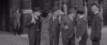 Movie still from “One, Two, Three” (1961), directed by Billy Wilder – A black and white photo of a group of men wearing hats; Medium shot, High angle