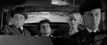 Movie still from “One, Two, Three” (1961), directed by Billy Wilder – A man and a woman in the back seat of a car; Medium shot, High angle