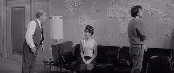Movie still from “One, Two, Three” (1961), directed by Billy Wilder – A black and white photo of a woman sitting on a couch; Medium shot, High angle