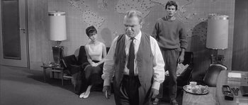 Movie still from “One, Two, Three” (1961), directed by Billy Wilder – An old photo of a man and two young women; Medium shot, Over the shoulder angle