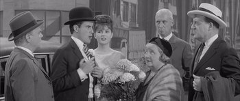 Movie still from “One, Two, Three” (1961), directed by Billy Wilder – An old black and white photo of a man and a woman; Medium shot, Over the shoulder angle