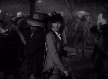 Movie still from “Only Angels Have Wings” (1939), directed by Howard Hawks – An old photo of a man in a suit and hat; Medium shot, Over the shoulder angle