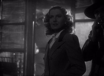 Movie still from “Only Angels Have Wings” (1939), directed by Howard Hawks – A black and white photo of a woman in a suit and tie; Medium shot, Low angle