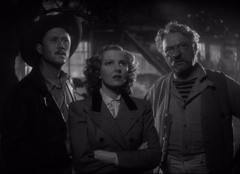 Movie still from “Only Angels Have Wings” (1939), directed by Howard Hawks – A black and white photo of a man and two women; Medium shot, Low angle