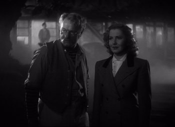 Movie still from “Only Angels Have Wings” (1939), directed by Howard Hawks – A man and a woman standing next to each other; Medium shot, Low angle