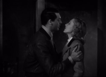 Movie still from “Only Angels Have Wings” (1939), directed by Howard Hawks – A man and a woman are kissing in a dark room; Medium shot, Low angle