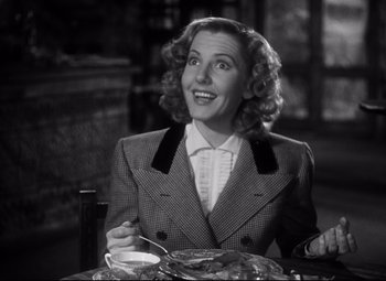 Movie still from “Only Angels Have Wings” (1939), directed by Howard Hawks – A woman sitting at a table with a plate of food in front of her; Medium shot, Low angle