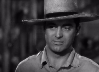 Movie still from “Only Angels Have Wings” (1939), directed by Howard Hawks – A black and white photo of a man wearing a cowboy hat; Close Up shot, Over the shoulder angle