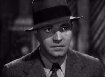 Movie still from “Only Angels Have Wings” (1939), directed by Howard Hawks – A man wearing a suit and a hat; Close Up shot, High angle