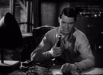 Movie still from “Only Angels Have Wings” (1939), directed by Howard Hawks – A man sitting at a desk holding a microphone; Close Up shot, Low angle