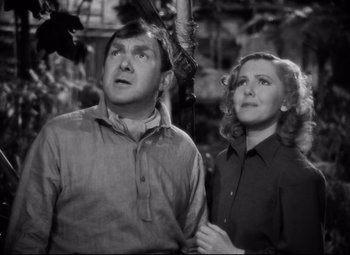 Movie still from “Only Angels Have Wings” (1939), directed by Howard Hawks – A man and a woman looking up at a tree; Medium shot, Low angle