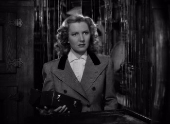 Movie still from “Only Angels Have Wings” (1939), directed by Howard Hawks – A black and white photo of a woman holding a purse; Medium shot, Low angle