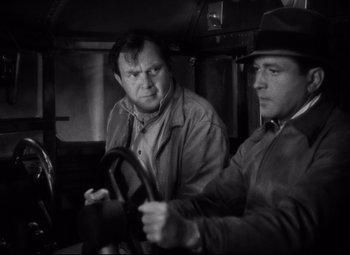 Movie still from “Only Angels Have Wings” (1939), directed by Howard Hawks – Two men are sitting in a car and one is holding the steering wheel; Close Up shot, Over the shoulder angle