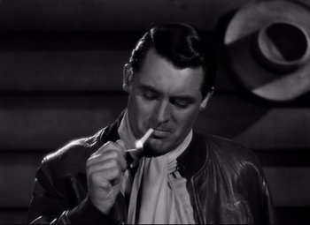 Movie still from “Only Angels Have Wings” (1939), directed by Howard Hawks – A black and white photo of a man smoking a cigarette; Close Up shot, Over the shoulder angle