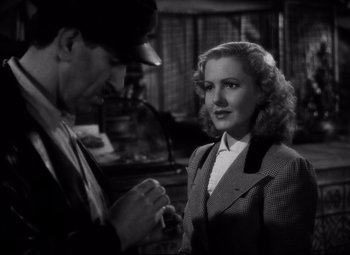 Movie still from “Only Angels Have Wings” (1939), directed by Howard Hawks – A man standing next to a woman wearing a suit; Close Up shot, High angle