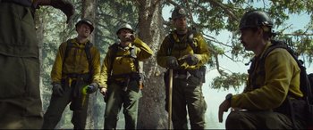 Movie still from “Only the Brave” (2017), directed by Joseph Kosinski – A group of men standing next to a tree; Wide shot, Low angle