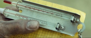 Movie still from “Only the Brave” (2017), directed by Joseph Kosinski – A hand that is holding a measuring tool; Extreme Close Up shot, Overhead angle