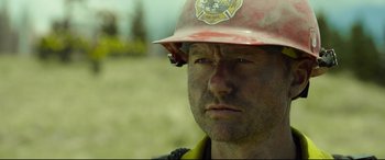 Movie still from “Only the Brave” (2017), directed by Joseph Kosinski – A person wearing a helmet; Close Up shot, Over the shoulder angle