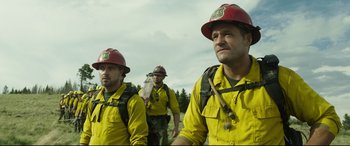 Movie still from “Only the Brave” (2017), directed by Joseph Kosinski – A group of men in yellow shirts and red hats; Medium shot, Low angle