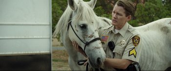 Movie still from “Only the Brave” (2017), directed by Joseph Kosinski – A man in uniform petting a white horse's head; Close Up shot, Over the shoulder angle