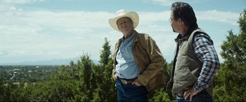 Movie still from “Only the Brave” (2017), directed by Joseph Kosinski – A man wearing a cowboy hat standing next to another man; Medium shot, Over the shoulder angle