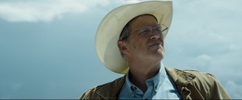 Movie still from “Only the Brave” (2017), directed by Joseph Kosinski – An older man wearing glasses and a cowboy hat; Close Up shot, Low angle