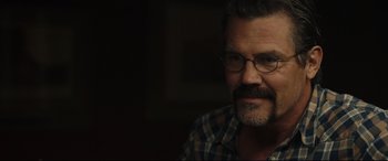 Movie still from “Only the Brave” (2017), directed by Joseph Kosinski – A person wearing glasses and a plaid shirt; Close Up shot, Over the shoulder angle