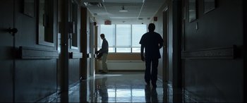 Movie still from “Only the Brave” (2017), directed by Joseph Kosinski – Two men are walking down a hallway in a building; Wide shot, Low angle