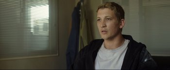 Movie still from “Only the Brave” (2017), directed by Joseph Kosinski – A young man in a white t - shirt and a black jacket; Close Up shot, Over the shoulder angle