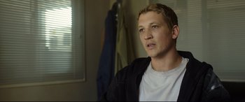 Movie still from “Only the Brave” (2017), directed by Joseph Kosinski – A young man in a white t - shirt and a black jacket; Close Up shot, Over the shoulder angle