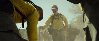 Movie still from “Only the Brave” (2017), directed by Joseph Kosinski – A man in a hard hat is holding a stick; Medium shot, Over the shoulder angle