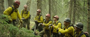 Movie still from “Only the Brave” (2017), directed by Joseph Kosinski – A group of men in the woods wearing hats; Wide shot, Over the shoulder angle